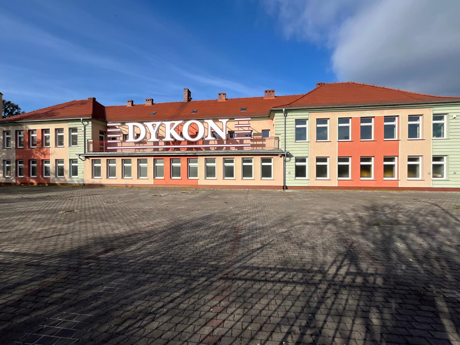 One-storey building with a colorful facade. View of parking by the building