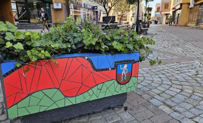 Donica mozaikowa w barwach miasta - niebieskim, czerwonym i zielonym oraz herbem Dzierżoniowa stojąca na ulicy Wrocławskiej.