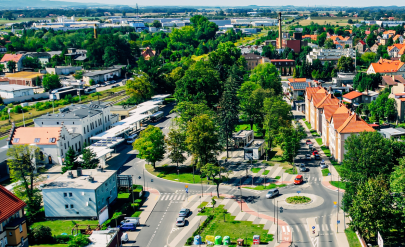 A fragment of Dzierżoniów from above, a lot of greenery, a parking lot and tenement houses. A fragment of Dzierżoniów from above, a lot of greenery, a parking lot and tenement houses.  ikona Zweryfikowane przez społeczność