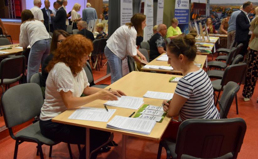 Dwie kobiety siedzą po przeciwnych stronach stołu i rozmawiają
