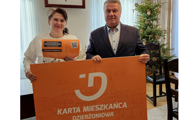 Dwie osoby trzymają pomarańczowy baner - Kartę Mieszkańca Dzierżoniowa