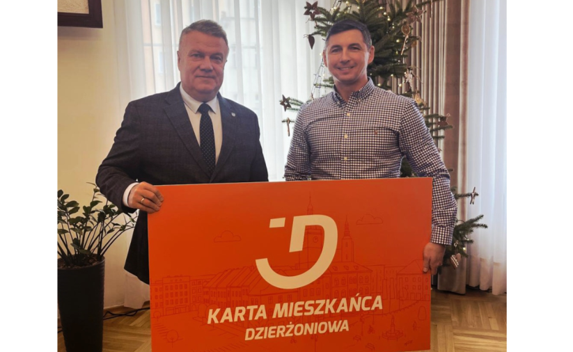 Dwie osoby trzymają pomarańczowy baner - Kartę Mieszkańca Dzierżoniowa