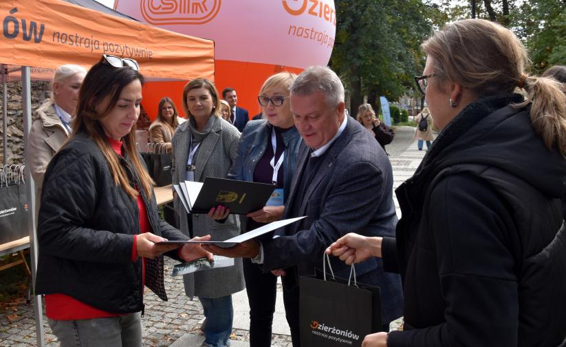 Burmistrz wręcza współorganizatorom podziękowania za udział w organizacji gry terenowej.