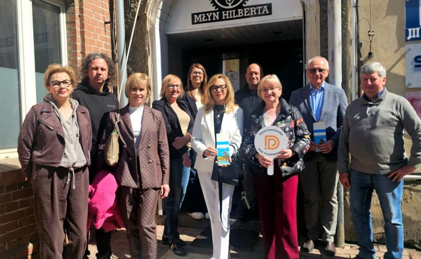grupa stojących osób przed wejściem do Młyna Hilberta w Dzierżoniowie