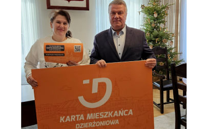 Dwie osoby trzymają pomarańczowy baner - Kartę Mieszkańca Dzierżoniowa
