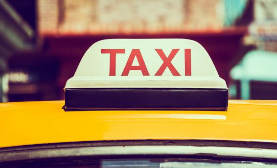 Zółty dach taksówki. Na dachu lampa z napisem TAXI.