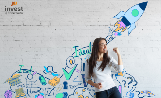 Woman against the background of a white wall. There are colorful graphics on the wall.