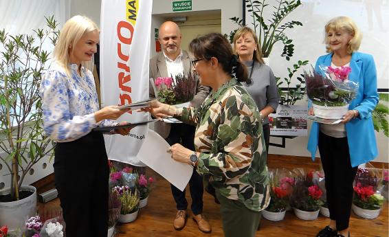 Awarding the prize to the competition winner. Four women and one man hold flowers in their hands.